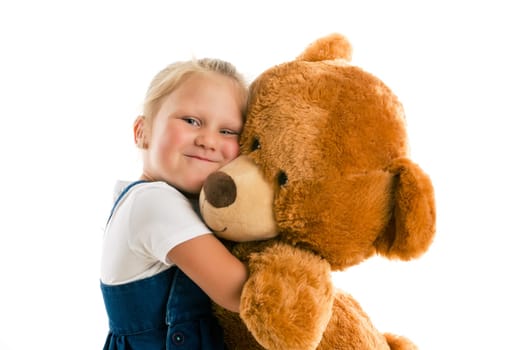 little girl with big teddy bear. studio shot