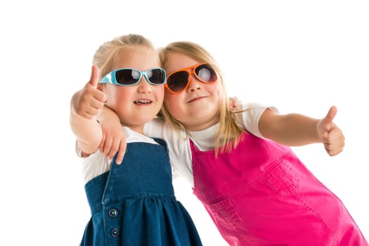 two little girls showing thumbs up. Studio shot.