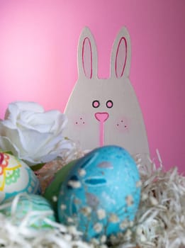 Flowers, Easter eggs and funny bunny to celebrate Easter. Space for copying. Wallpaper for Easter announcements and cards.