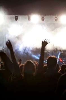 Cheering crowd in front of bright colorful stage lights