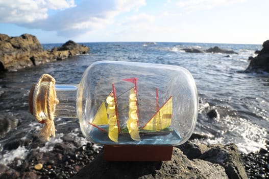Ancient Spanish Sailing Boat in a Bottle near the Ocean