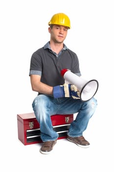 A craftsman sits on a toolbox and holds a megaphone