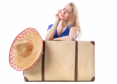 Blonde girl sits behind a suitcase
