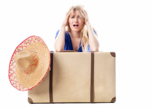 Blonde girl sits behind a suitcase