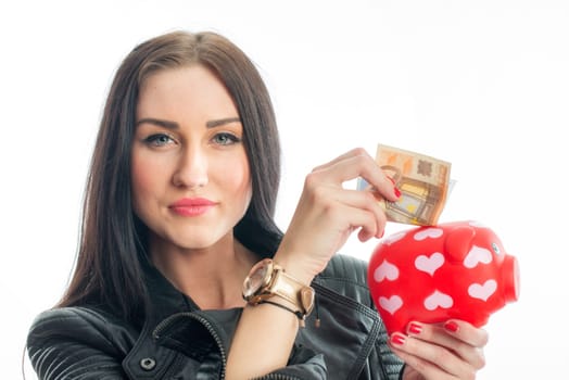 Woman puts money into a piggy bank
