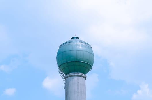 Water tower,storage tank in front of a blue sky cloudy slightly.