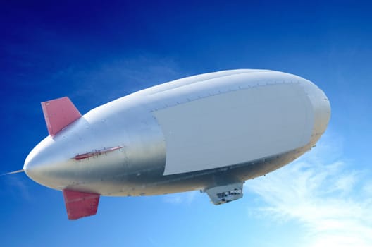 Airship,air giant in ascending flight in front of a blue sky.