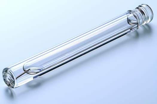 A clear glass tube lies on a reflective surface, highlighting its elongated design and smooth edges under soft lighting.