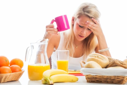 Blonde woman sits at the covered breakfast table