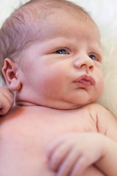 Little baby toddler newborn naked on a white fur as Detal