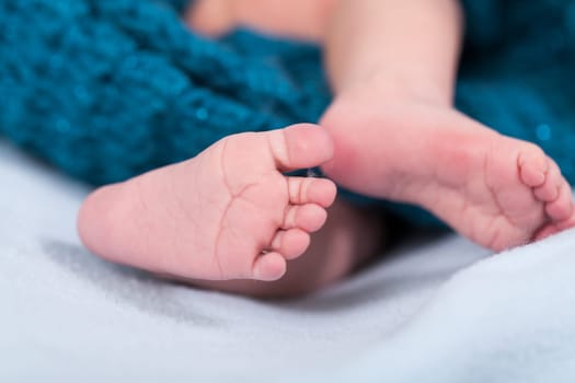 Newborn baby wrapped in a scarf sleeps naked as a close-up