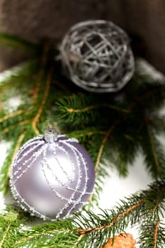 Silver Christmas tree balls in green fir branches with white shiny snow as macro detail