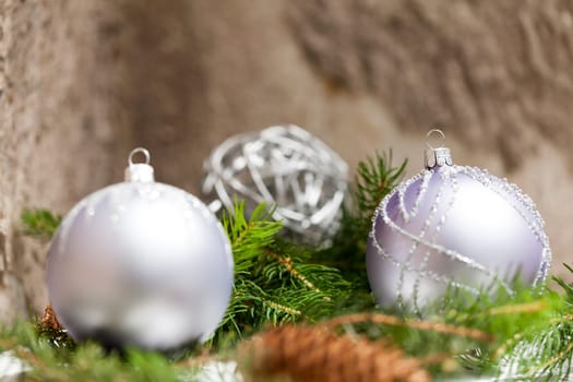 Silver Christmas tree balls in green fir branches with white shiny snow as macro detail