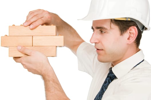 Side-body shot of a young man in white shirt and white helmet holding up wooden cooks against a white background