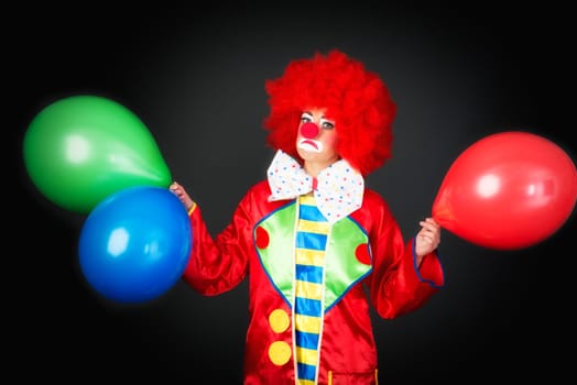 Sad clown with balloons