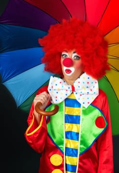 Astonished clown with umbrella
