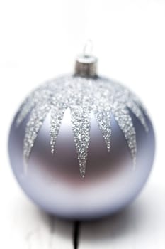 Glittering silver Christmas bauble on white background Macro detail