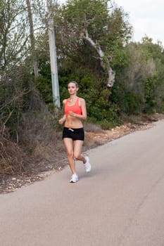 attractive sporty young woman jogging on an outdoor street in daylight