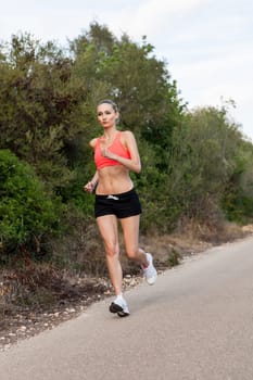 attractive sporty young woman jogging on an outdoor street in daylight