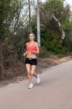 attractive sporty young woman jogging on an outdoor street in daylight