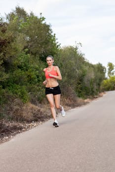attractive sporty young woman jogging on an outdoor street in daylight