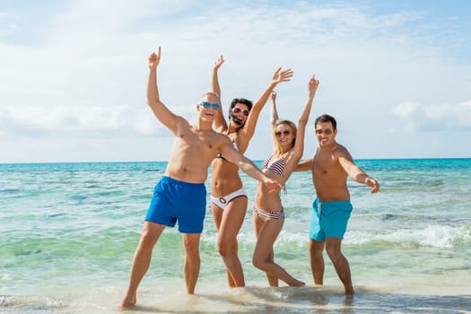 group of laughing young people on the beach in summer holiday leisure lifestyle