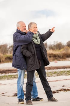 older adult happy couple walks on the beach in autumn lifestyle happiness