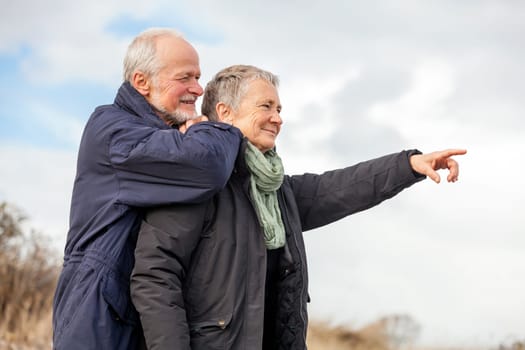 older adult happy couple walks on the beach in autumn lifestyle happiness