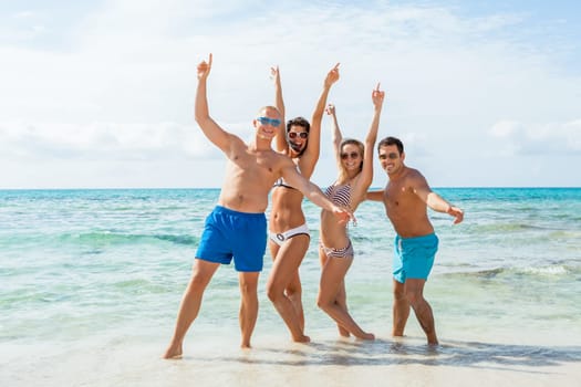 group of laughing young people on the beach in summer holiday leisure lifestyle