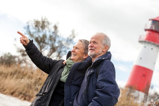 older happy couple makes a beach walk in autumn baltic sea landscape sea