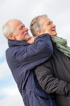 older adult happy couple walks on the beach in autumn lifestyle happiness