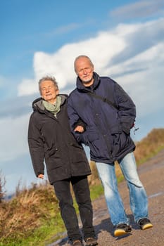 older happy couple makes a beach walk in autumn baltic sea landscape sea