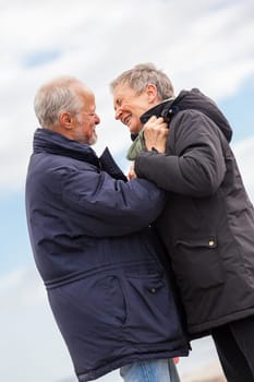 older adult happy couple walks on the beach in autumn lifestyle happiness