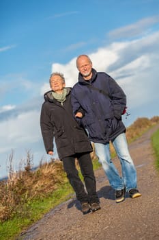 older happy couple makes a beach walk in autumn baltic sea landscape sea