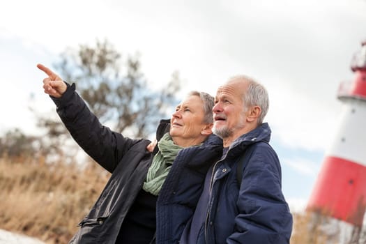 older happy couple makes a beach walk in autumn baltic sea landscape sea