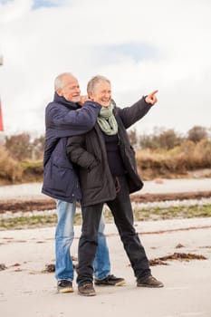 older adult happy couple walks on the beach in autumn lifestyle happiness