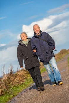 older happy couple makes a beach walk in autumn baltic sea landscape sea