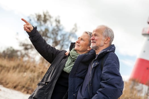 older happy couple makes a beach walk in autumn baltic sea landscape sea