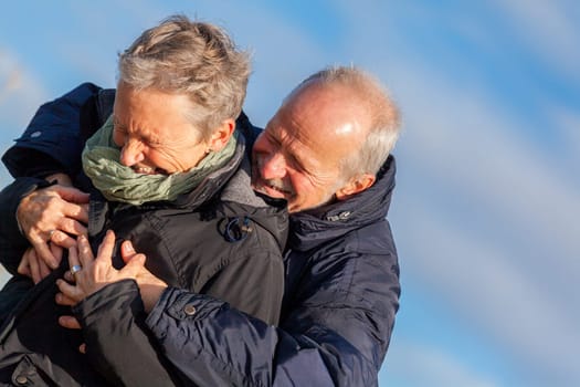 older seniors couple happy laughing in holiday leisure natural ostsee