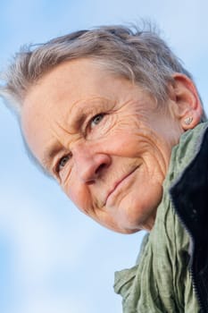 laughing happy older woman senior in autumn outside with jacket and scarf
