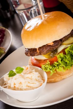 Delicious hamburger cheeseburger with bacon egg and salad on a plate