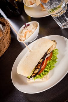 Vegetarian vegan hamburger with aubergine tomato and salad in a ciabatta bun