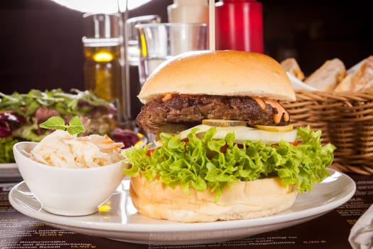 Delicious hamburger cheeseburger with bacon egg and salad on a plate