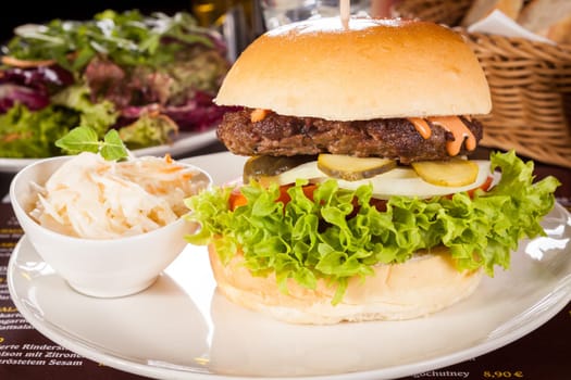 Delicious hamburger cheeseburger with bacon egg and salad on a plate