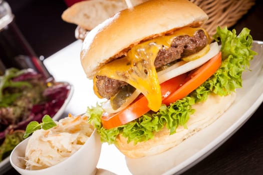 Delicious hamburger cheeseburger with bacon egg and salad on a plate
