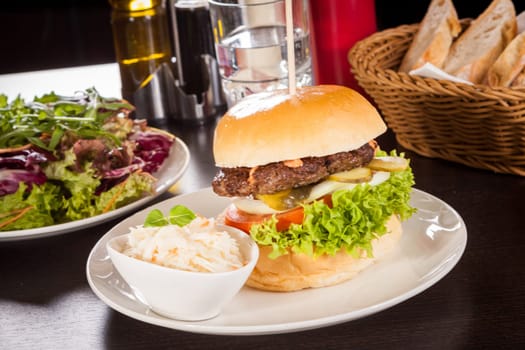 Delicious hamburger cheeseburger with bacon egg and salad on a plate