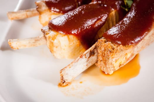 Grilled pork ribs Spareribs with barbecue sauce marinade and herb salad on a plate