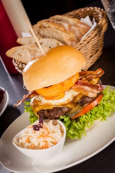 Delicious hamburger cheeseburger with bacon egg and salad on a plate