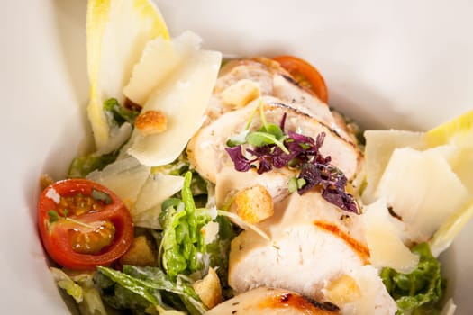 Fresh delicious caesarsalat with grilled chicken bust parmesan splinters and croutons
