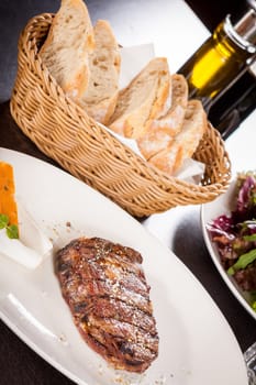 Succulent grilled beef fillet steak with homemade herb butter on a plate isolated against a white background